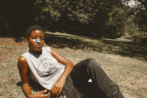 African American woman with blue zinc oxide sunscreen laying down outside on grass